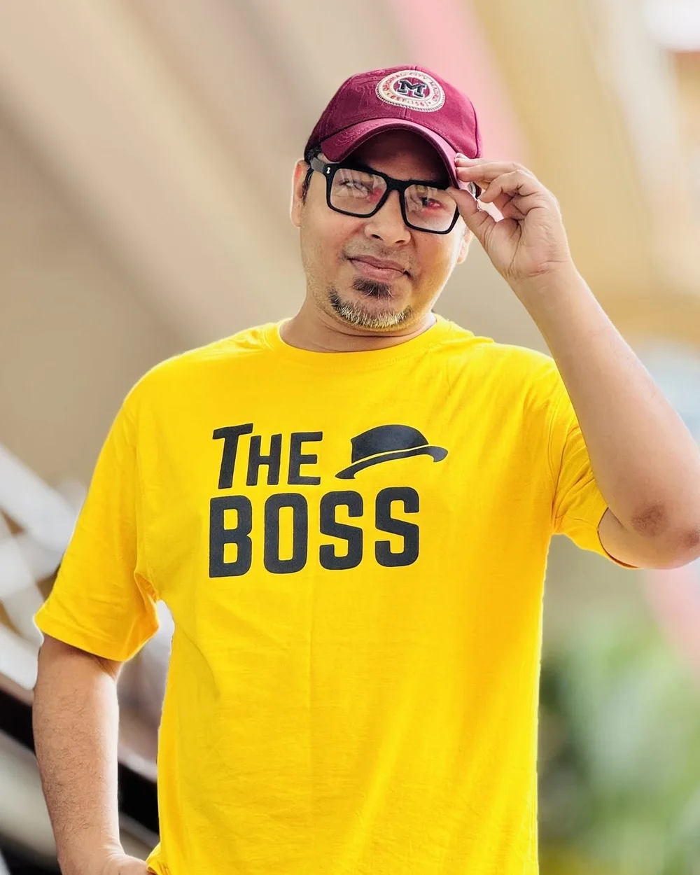 Shameek Khandoker Monon in a yellow T-shirt and maroon cap, smiling