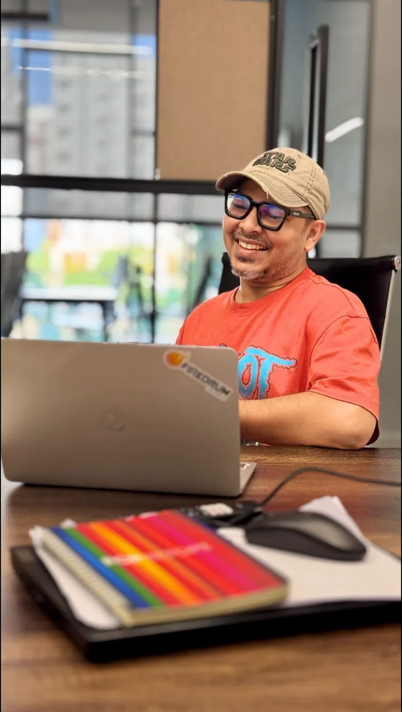 Monon smiling at his laptop with a FireDrum sticker